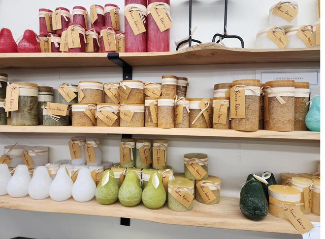 Jars and pear-shaped candles on a live-edge shelf.