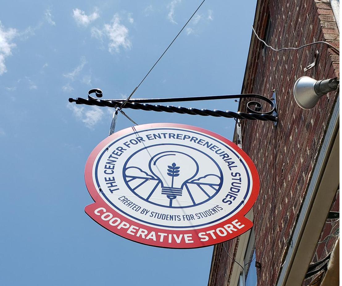 The CES Cooperative Store sign hanging above the sidewalk.